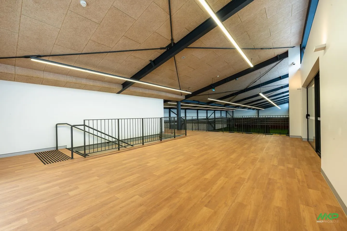 Completed interior with timber floor, exposed steel and suspended lighting