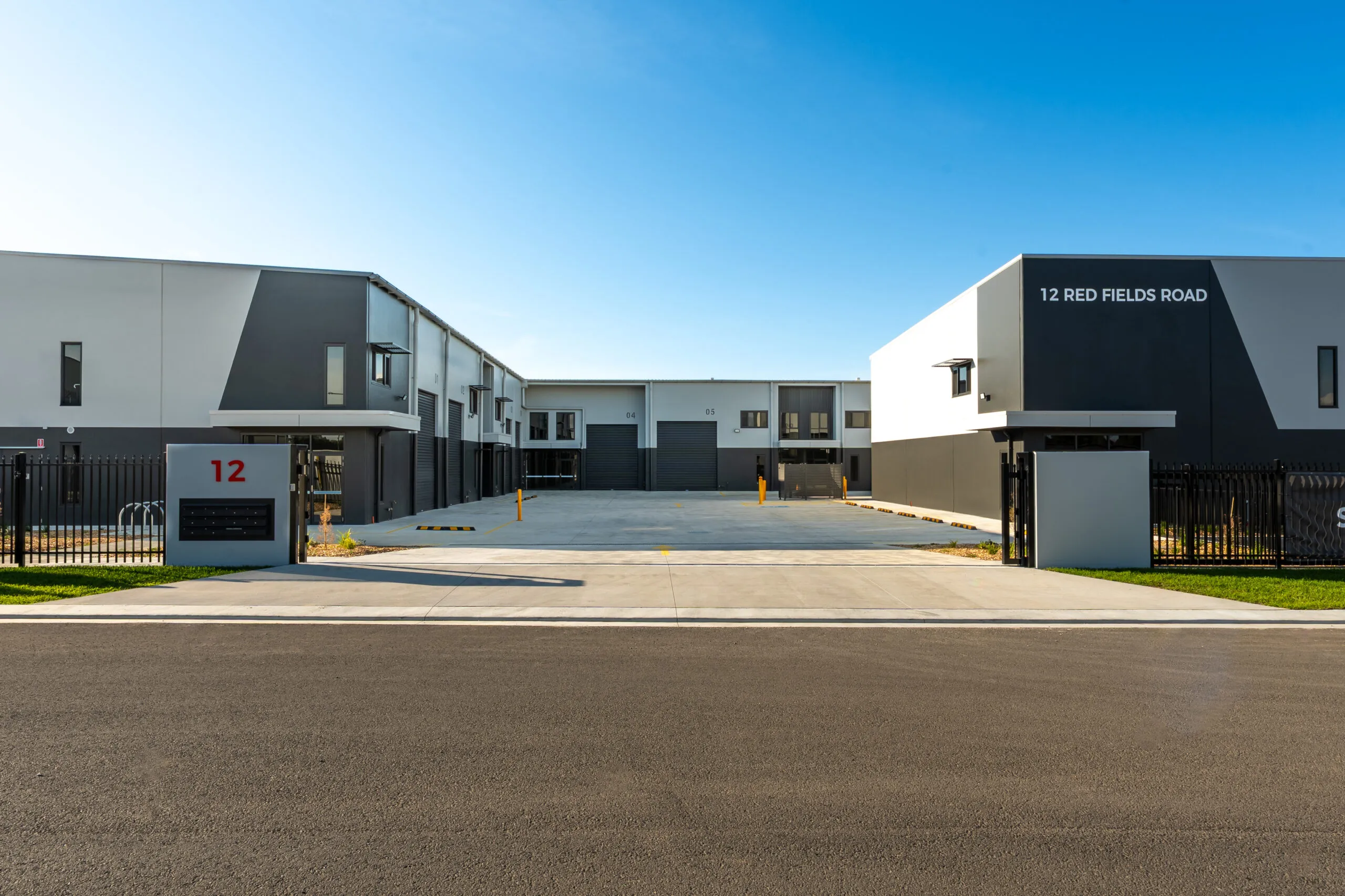 Completed industrial warehouse units with a concrete forecourt