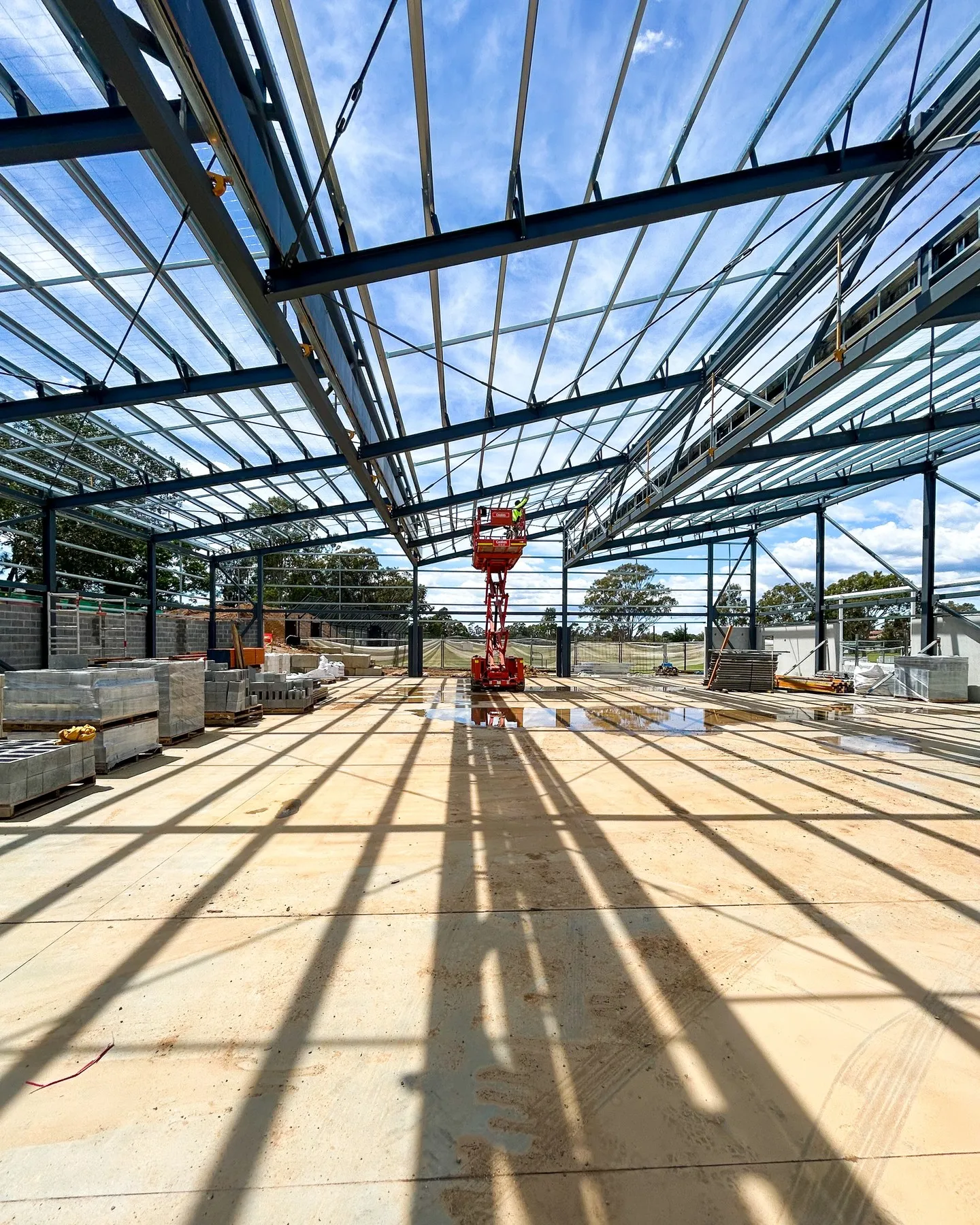 Steel roof framing being installed inside a community sports building